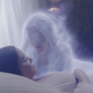 This image shows a woman sleeping and a spirit loved one lovingly bending over her.