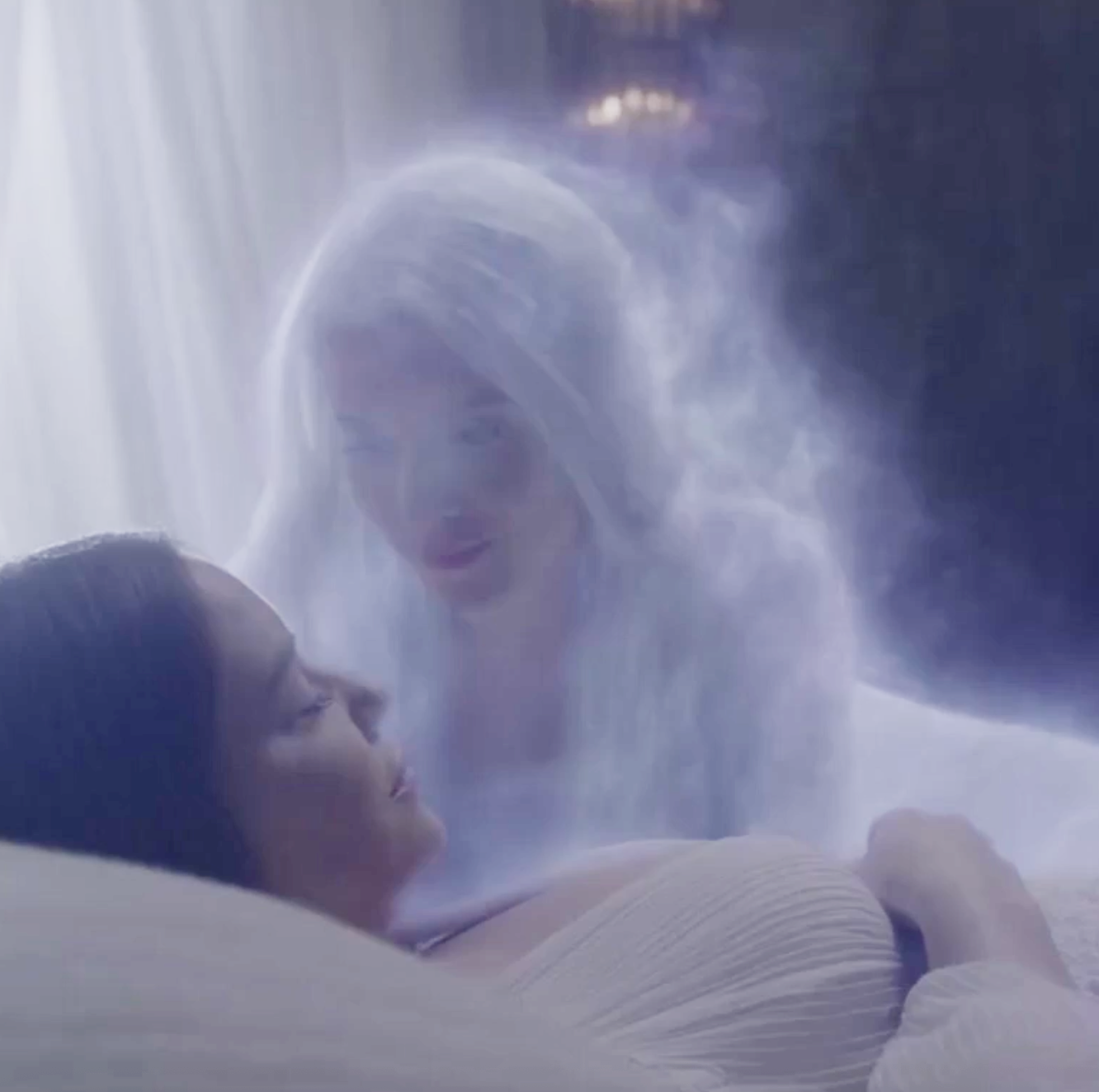 This image shows a woman sleeping and a spirit loved one lovingly bending over her.